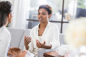 Concerned African American woman is vulnerable while discussing issues with her therapist.